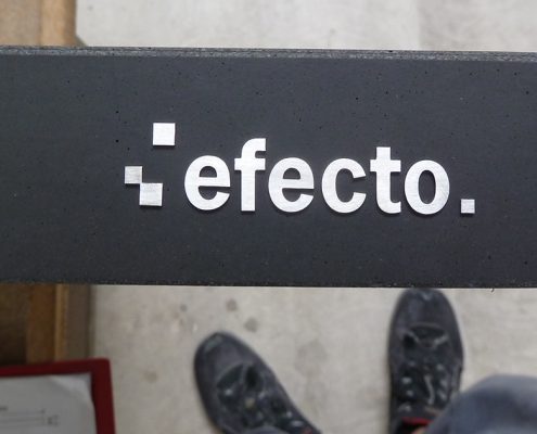 efecto Logo aus Edelstahl auf Betonelement