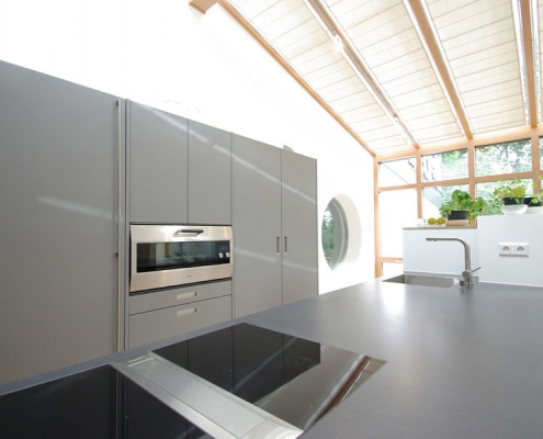 moderne graue Kueche mit Arbeitsflaeche Kochinsel aus Beton